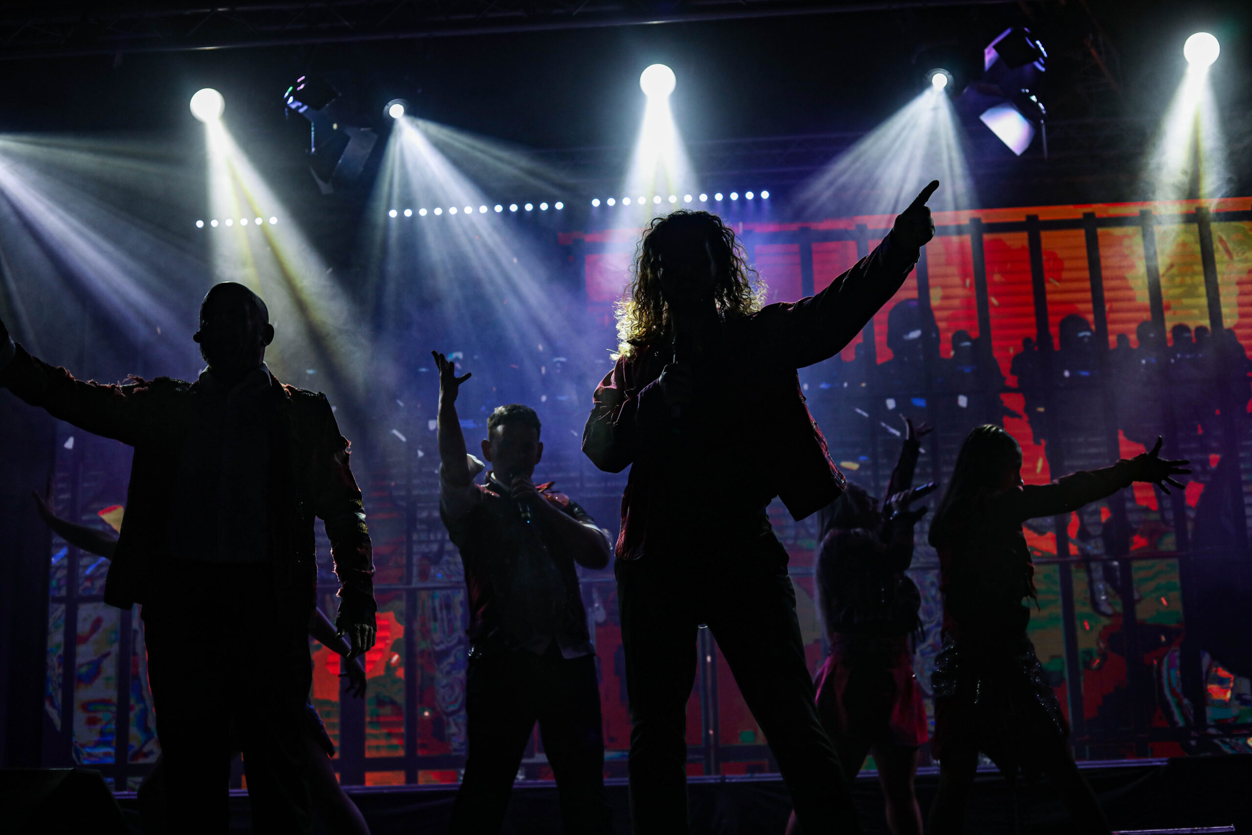 The Viva cast on stage singing and in silhouette during a performance at the Viva Blackpool venue
